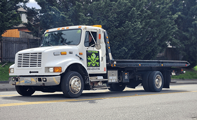 The Diesel Doctor white flatbed tow truck parked on an Arlington street.